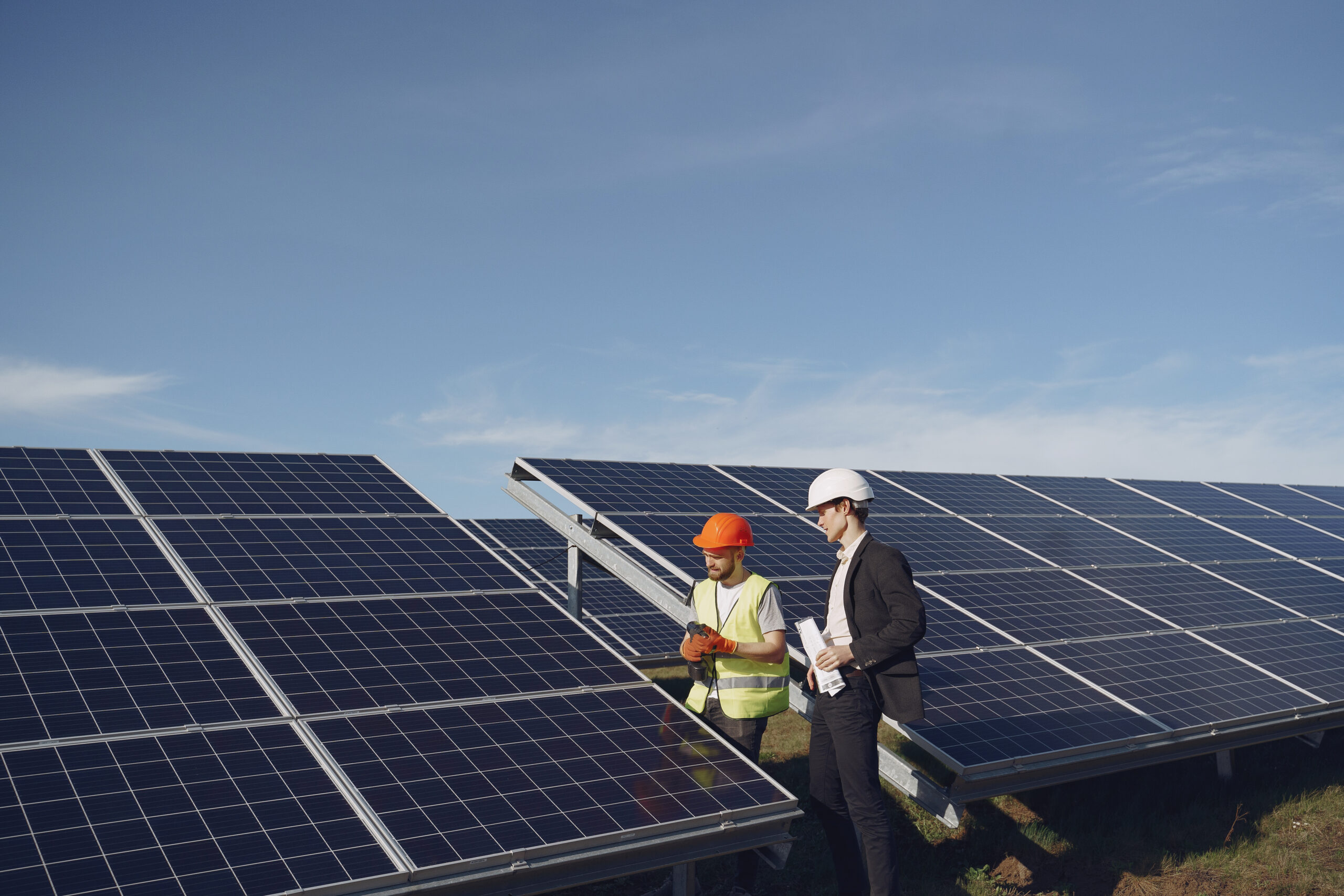 Businessman and worker near solar energy batteries. Business client showing photovoltaic detail to foreman. Two men making deal.