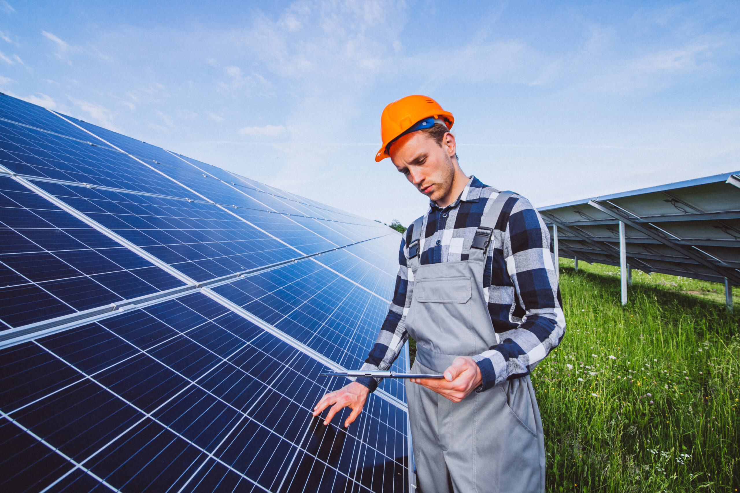 Man worker in the firld by the solar panels