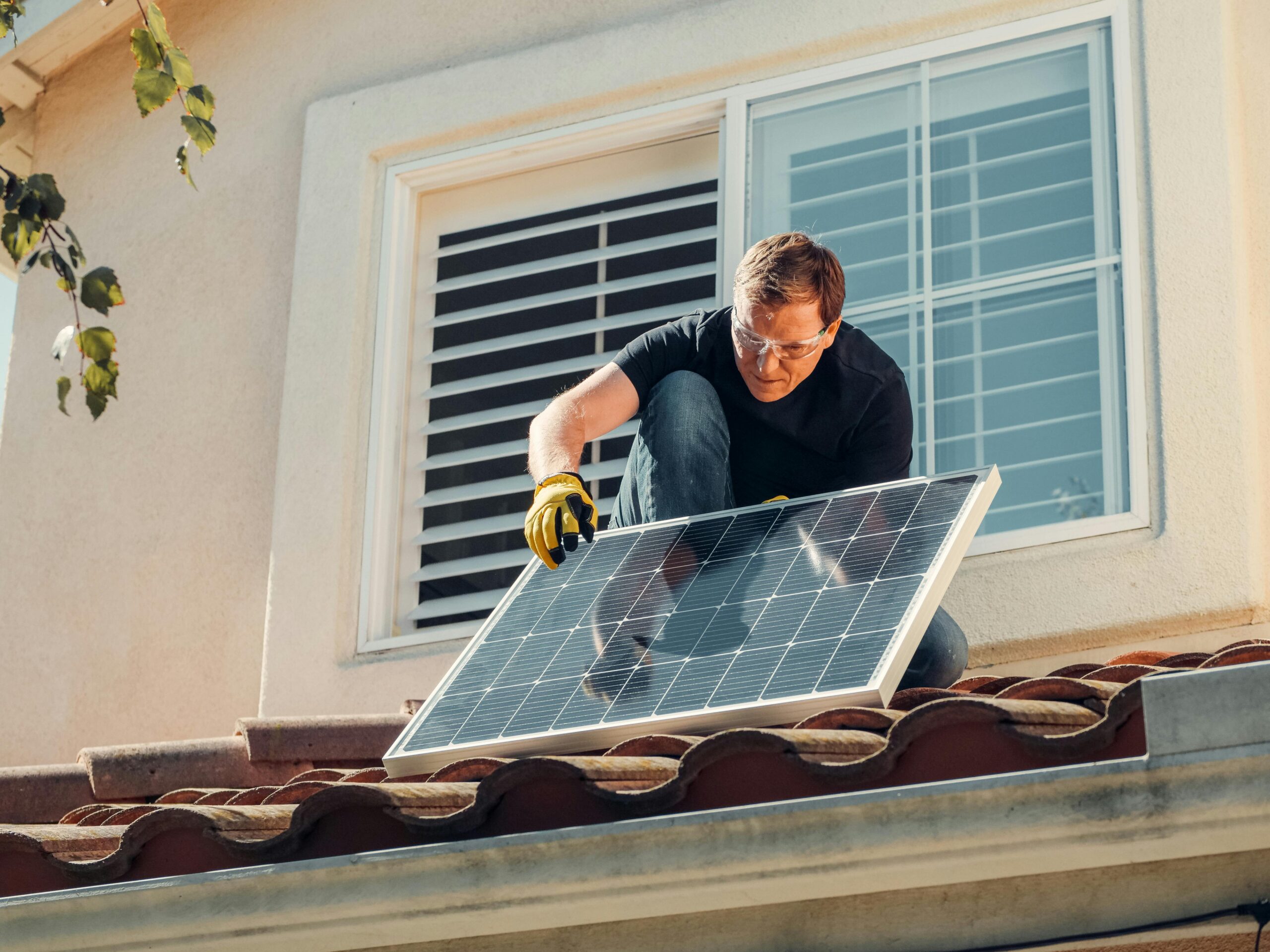 Solar technician installing a photovoltaic panel on a rooftop, promoting renewable energy.